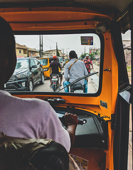 Keke view onto busy city street — tricycles, bikes and cars